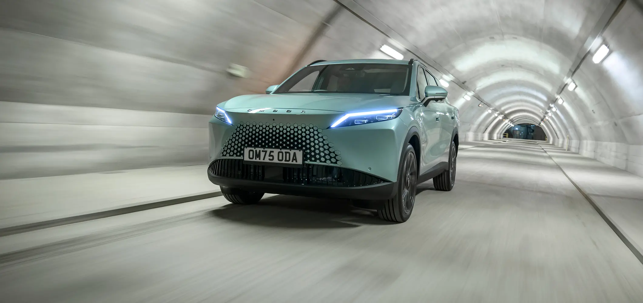 Close up of OMODA 7 with lit headlights in tunnel