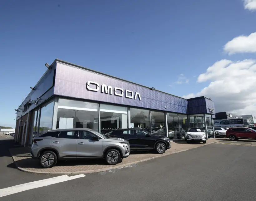 Wide angle shot of OMODA dealership with OMODA cars parked in front of the building