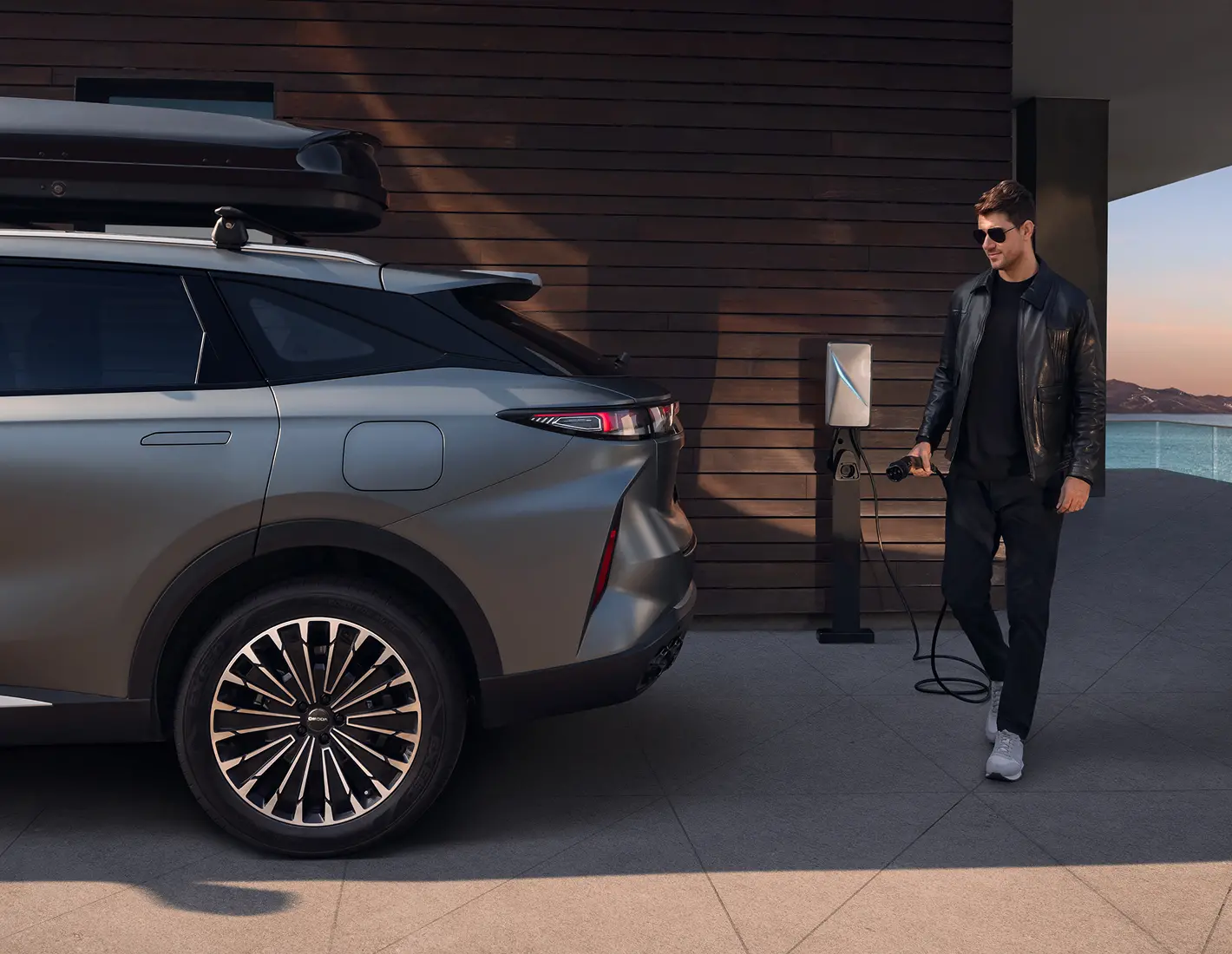 Man holding charger for an OMODA EV in Dark grey